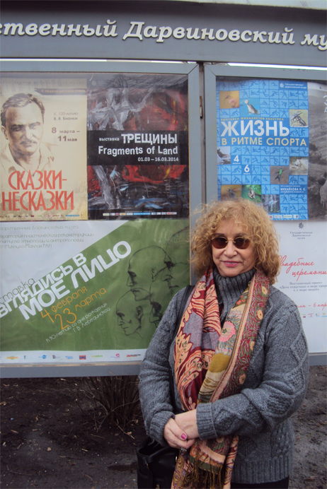 Lenir posando ao lado de cartazes em russo